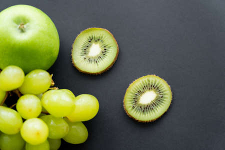 top view of green and tasty fruits on blackの写真素材