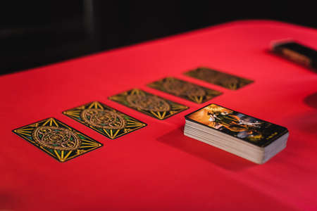KYIV, UKRAINE - FEBRUARY 23, 2022: Tarot cards on red table isolated on blackのeditorial素材