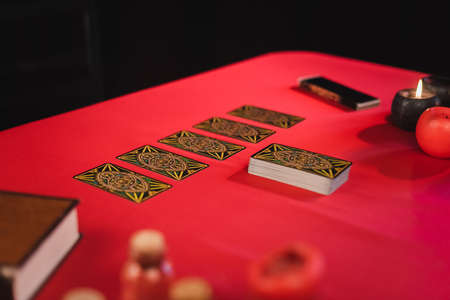 KYIV, UKRAINE - FEBRUARY 23, 2022: Tarot near candles and blurred book on table isolated on blackのeditorial素材