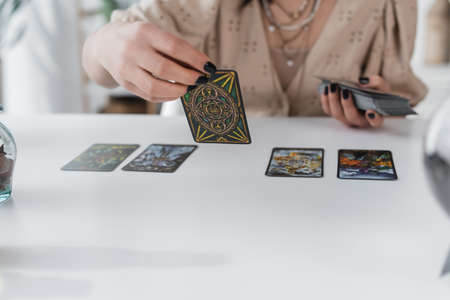 KYIV, UKRAINE - FEBRUARY 23, 2022: Cropped view of blurred medium holding tarot cards at homeのeditorial素材