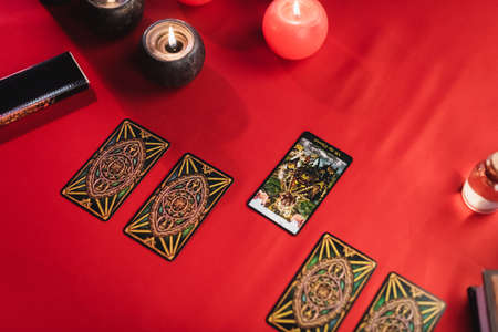 KYIV, UKRAINE - FEBRUARY 23, 2022: Top view of tarot cards near burning candles on tableのeditorial素材