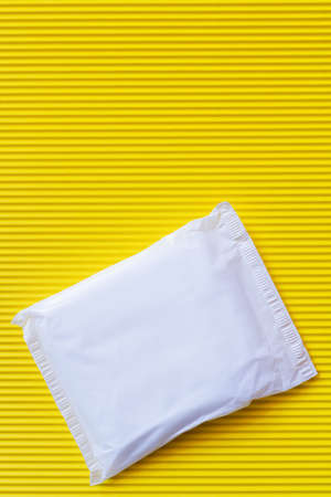 top view of packed panty liner on textured yellow backgroundの写真素材