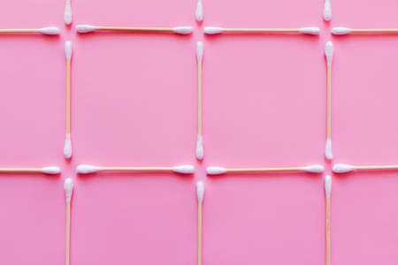 top view of squares made of cotton swabs on pink background