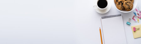 top view of cup of coffee, cookies and stationery near smartphone with blank screen on white, bannerの写真素材