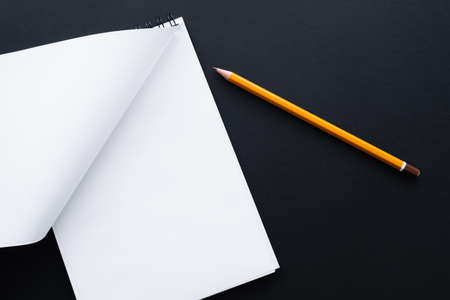 top view of blank notebook and pencil on blackの写真素材