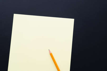 top view of blank pastel color paper with pencil on blackの写真素材
