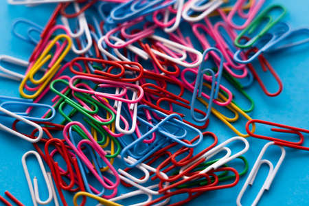 close up view of colorful paper clips on blueの写真素材
