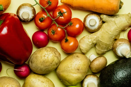 Top view of natural vegetables and avocado on yellow backgroundの写真素材