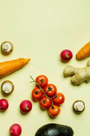 Top view of organic vegetables and avocado on yellow backgroundの写真素材
