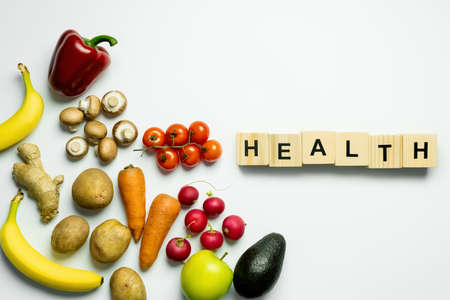 Top view of wooden cubes with health lettering near food on white background