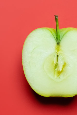 Close up view of cut fresh apple on red backgroundの写真素材