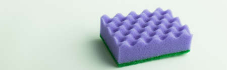 textured purple kitchen sponge on grey background, banner