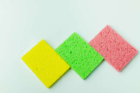 top view of yellow, green and pink sponge rugs on grey backgroundの写真素材