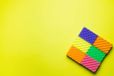 top view of textured multicolored sponges on bright yellow background