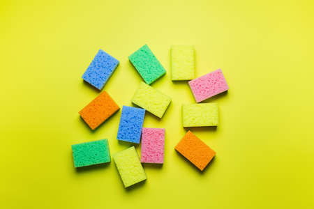 plenty of bright multicolored sponges on yellow background, top viewの写真素材