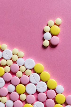 flat lay view of different round shape pills on pink background