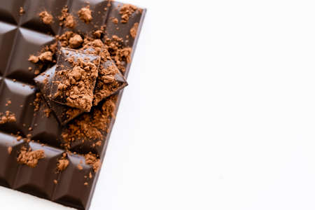Top view of cocoa powder on dark chocolate on white background