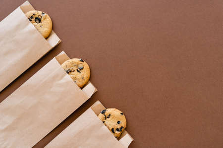 Top view of cookies in craft packages on brown background with copy spaceの写真素材