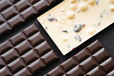 Top view of white and dark chocolate bars on black background