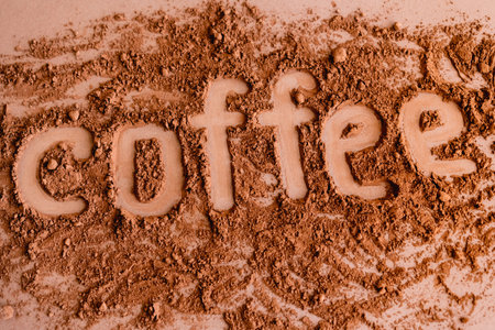 Top view of coffee lettering in cocoa on brown backgroundの写真素材