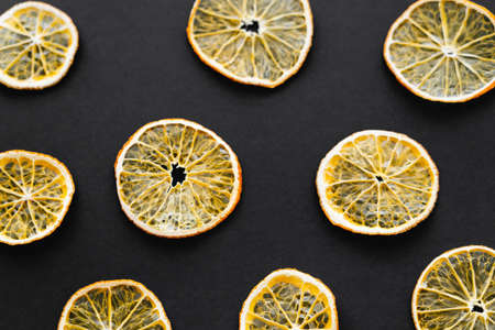Top view of dry orange slices on black backgroundの写真素材