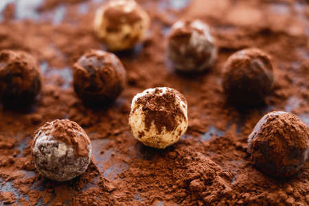 Close up view of tasty candies with cocoa on black backgroundの写真素材