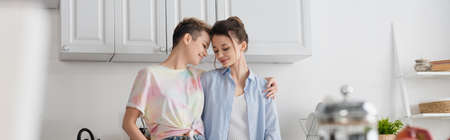 happy pansexual partners embracing in kitchen, banner