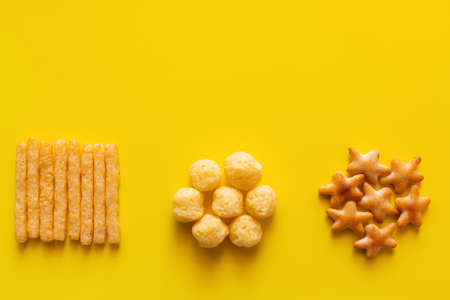 top view of tasty french fries, cheese pops and bakes star shape cookies on yellowの写真素材