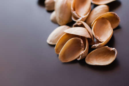 close up view of shells form pistachio nuts on black