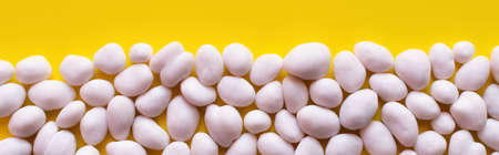 flay lay with row of tasty pine nuts on yellow background, bannerの写真素材