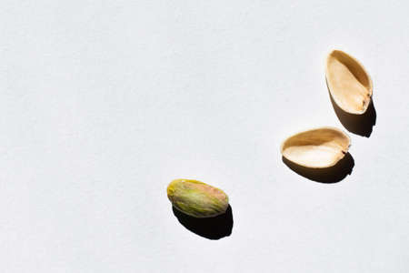top view of cracked green and salty pistachio on white backgroundの写真素材