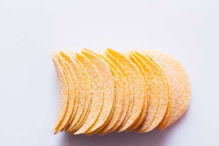 top view of salty and crunchy potato chips on white