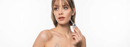 young woman with bangs holding bottle with serum and pipette isolated on white, banner