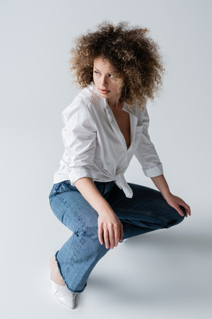 Pretty curly model posing on white backgroundの写真素材
