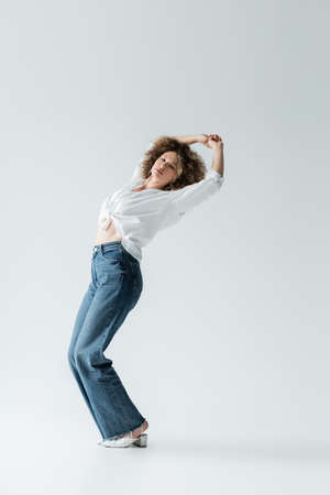 Stylish woman closing yes and posing on white backgroundの写真素材