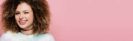 Young woman winking and smiling at camera isolated on pink, bannerの写真素材