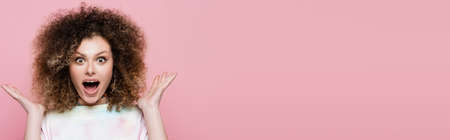 Amazed woman looking at camera isolated on pink, bannerの写真素材