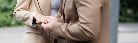 partial view of man putting wedding ring on finger of girlfriend outdoors, bannerの写真素材