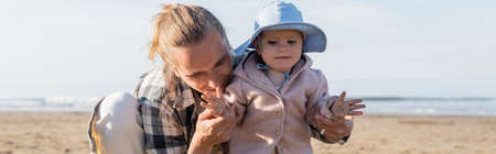 Man holding hands of baby daughter on beach in Italy, banner