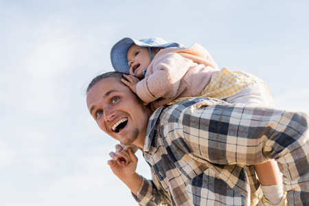 Low angle view of positive father and baby girl having fun with sky at backgroundの写真素材