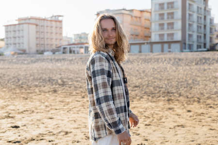 Long haired man standing on beach in Italyの写真素材