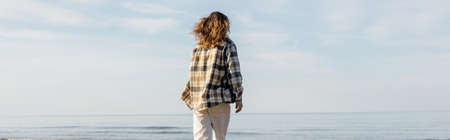 Back view of long haired man standing near adriatic sea in Treviso, bannerの写真素材