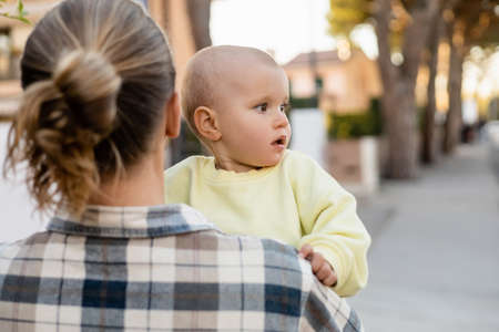 Blurred man holding toddler kid on urban streetの写真素材