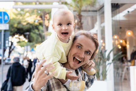 Excited father and child looking away on urban street in Trevisoの写真素材
