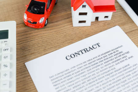 top view of contract near house model and toy car on tableの写真素材