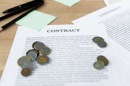 silver and golden coins on contract near pensの写真素材