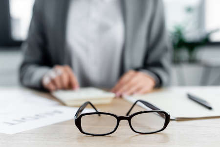 selective focus of glasses near chief financial officer in officeの写真素材