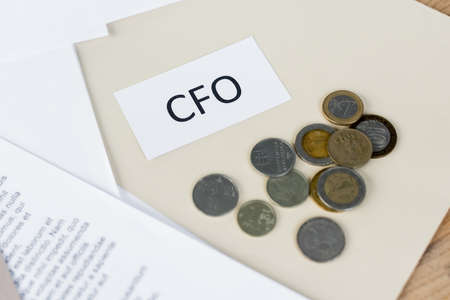 top view of paper with cfo lettering near coins and documentsの写真素材