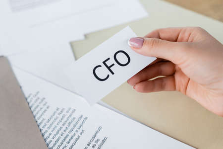 cropped view of woman holding paper with cfo letteringの写真素材