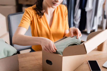 Cropped view of owner putting clothes in box in online web storeの写真素材